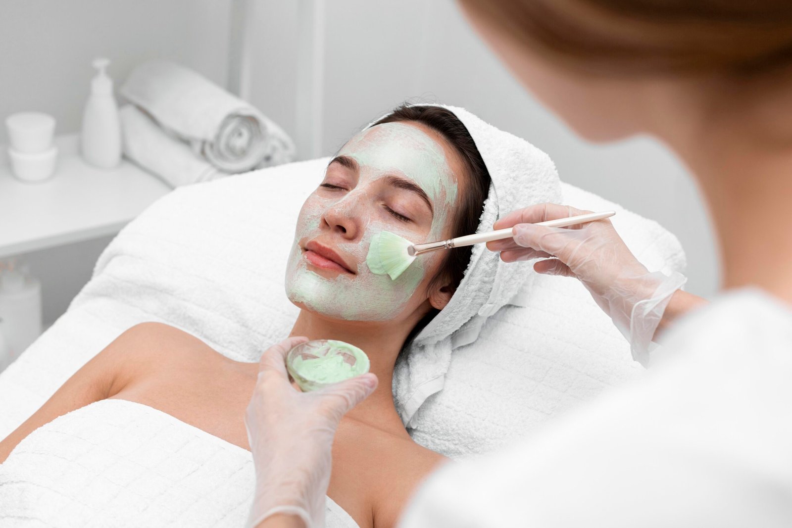 beautician-applying-face-mask-female-client